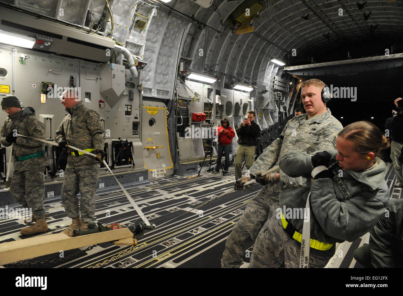 Members of the 305th Aerial Port Squadron load a mobile command and control unit onto C-17 Joint Base McGuire-Dix-Lakehurst AFB, New Jersey Jan. 15, 2010. Air Mobility Command is responding with all necessary forces and equipment to aide the humanitarian efforts in Haiti. Senior Airman Katie Gieratz Stock Photo