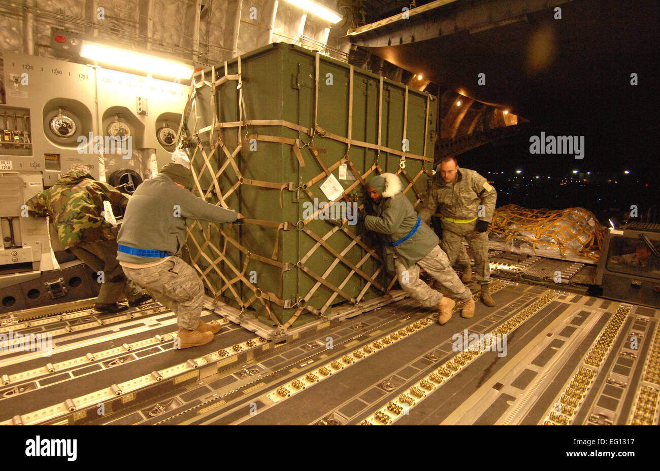 U.S. Air Force service members from the 305th Aerial Port Squadron, out of McGuire, AFB, New Jersey, load humanitarian supplies Friday, January 15th, 2010, onto a C-17A Globemaster from the 729th Airlift Squadron, out of March, Air Reserve Base, bound for the Port-au-Prince International Airport, Haiti. The C-17 and crew, both out of the 452nd Air Mobility Wing at March Air Reserve Base, are taking part in the massive international effort to assist in rescue, recovery and humanitarian efforts following a 7.0 earthquake. President Barack Obama ordered a swift and aggressive rescue effort.  The  Stock Photo