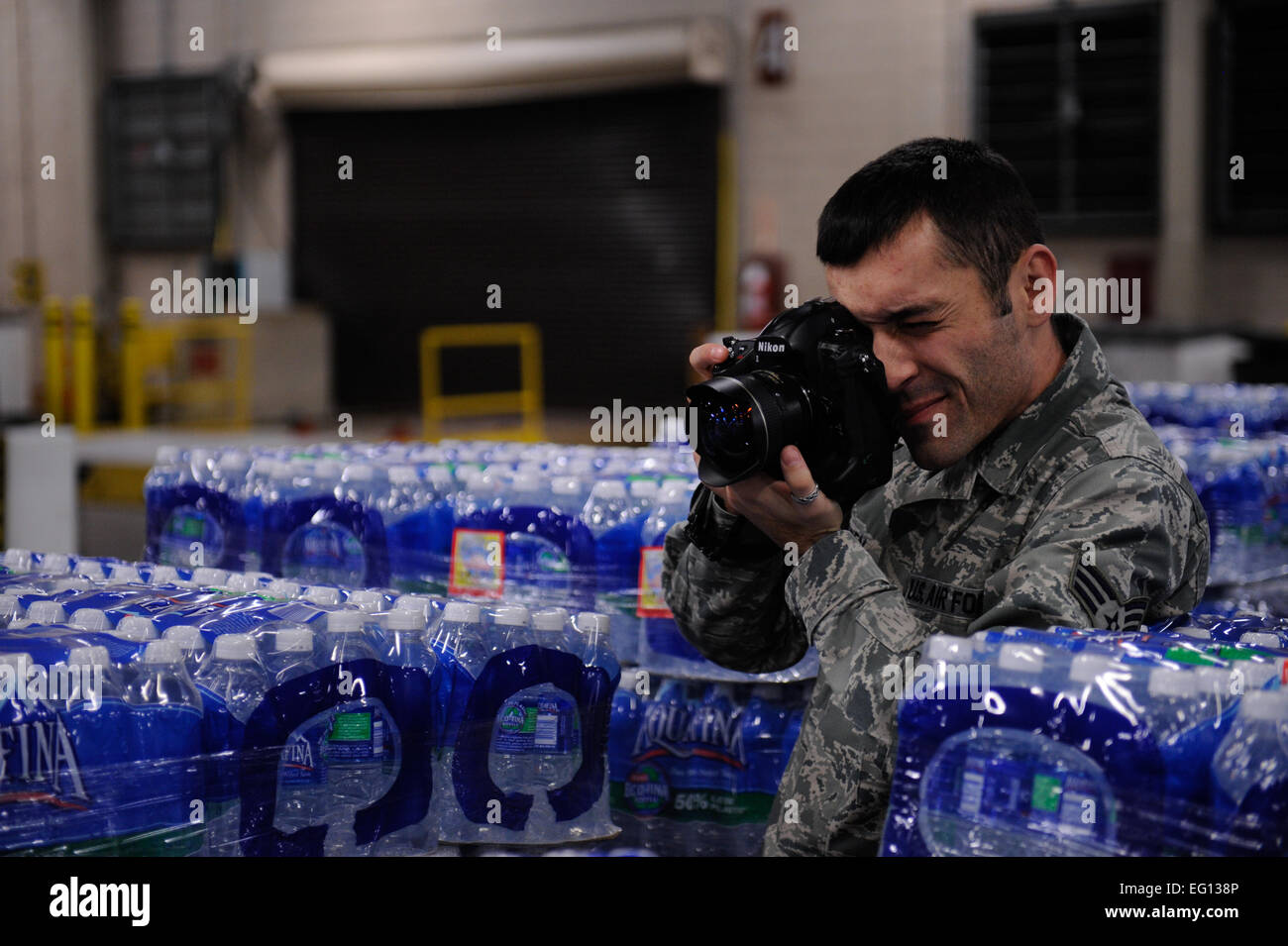 U.S. Air Force Senior Airman Daniel Owen of the 1st Combat Camera Squadron photographs water being unloaded for the Haiti humanitarian relief effort on Jan. 16,2010 on Charleston Air Force Base S.C. Airman 1st Class Jeremy Burns Released/Not Reviewed Stock Photo
