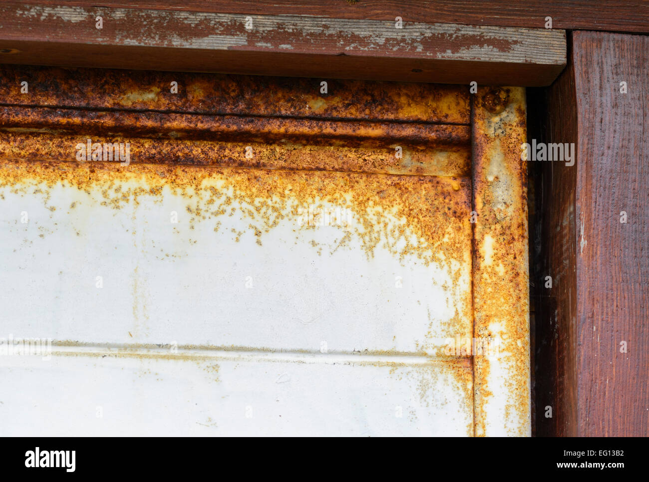 Top and side of an old metallic garage door with a lot of rust, rot, decay and oxidation. Stock Photo