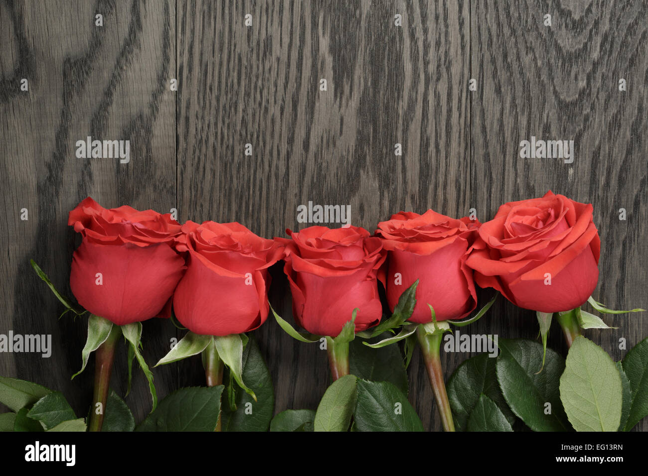 Romantic background with red roses on wood table Stock Photo - Alamy