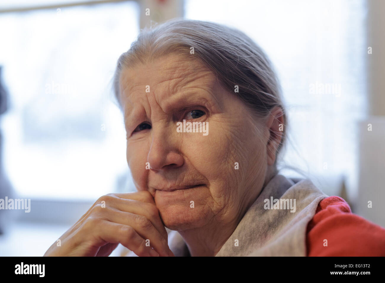 portrait of senior woman siting near the window Stock Photo