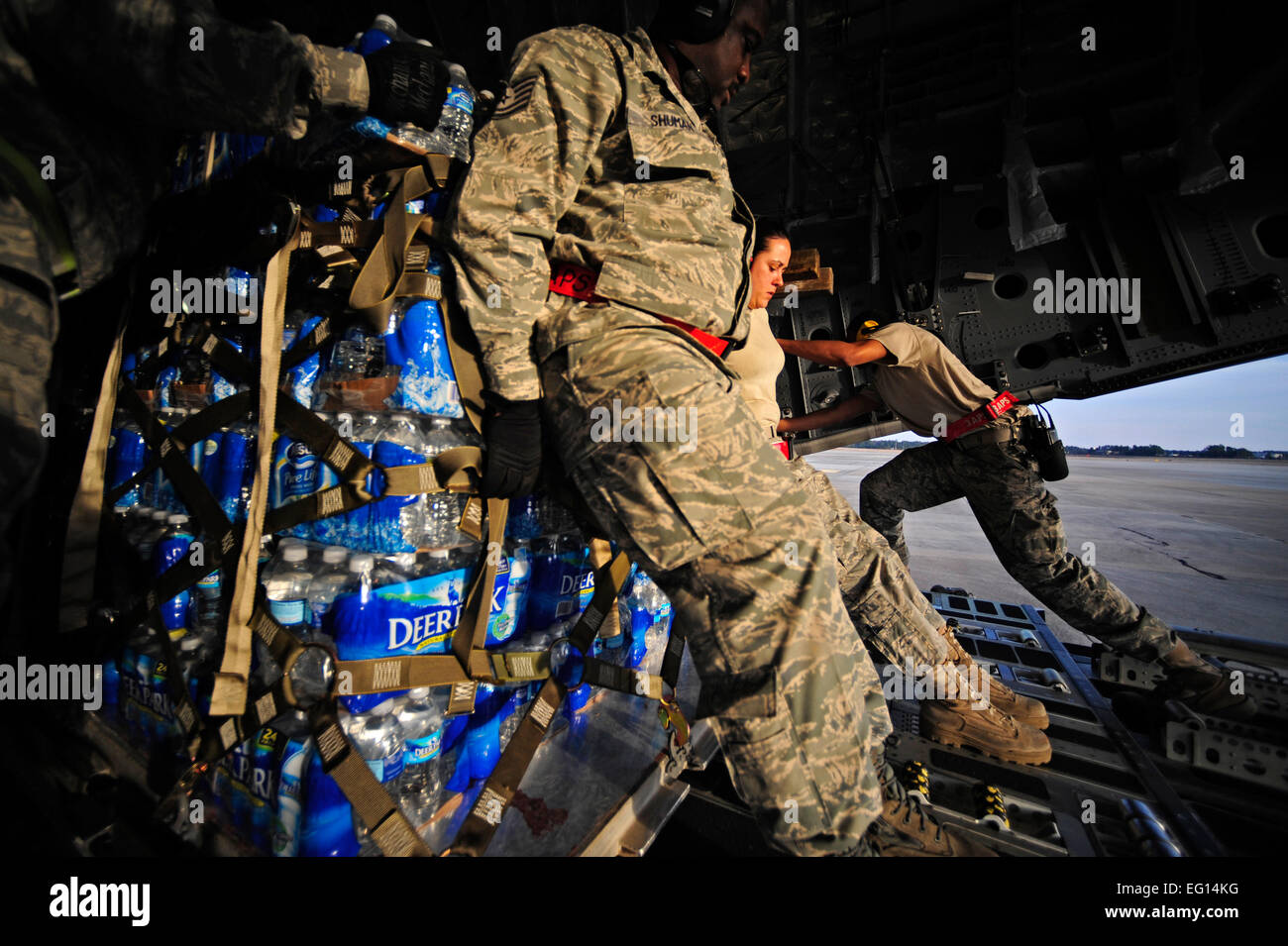 Airmen push a pallet of water onto a C17 Globemaster III aircraft