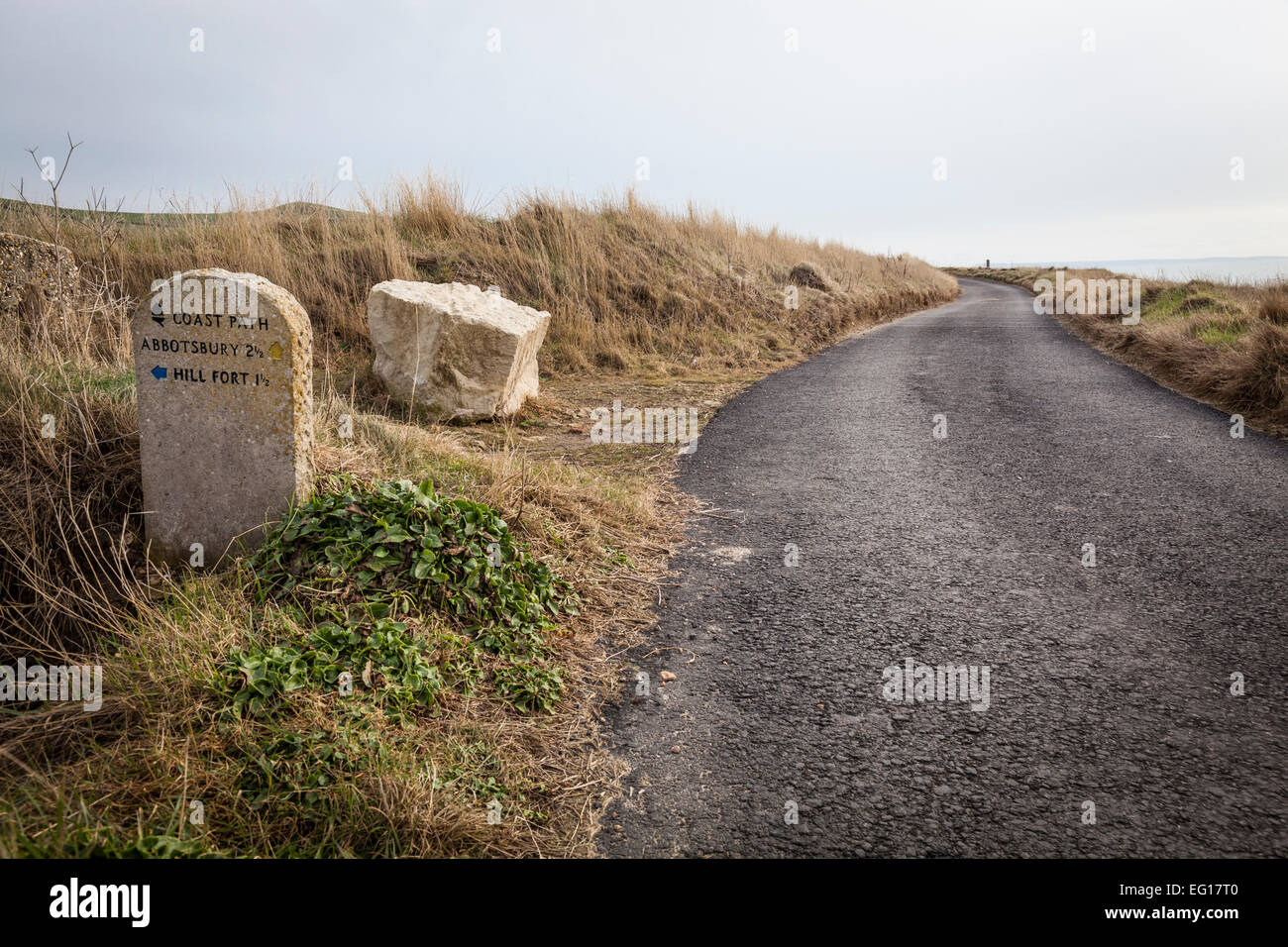 Stone milepost alongside the Southwest Coastal Path besides Chesil Beach. Stock Photo