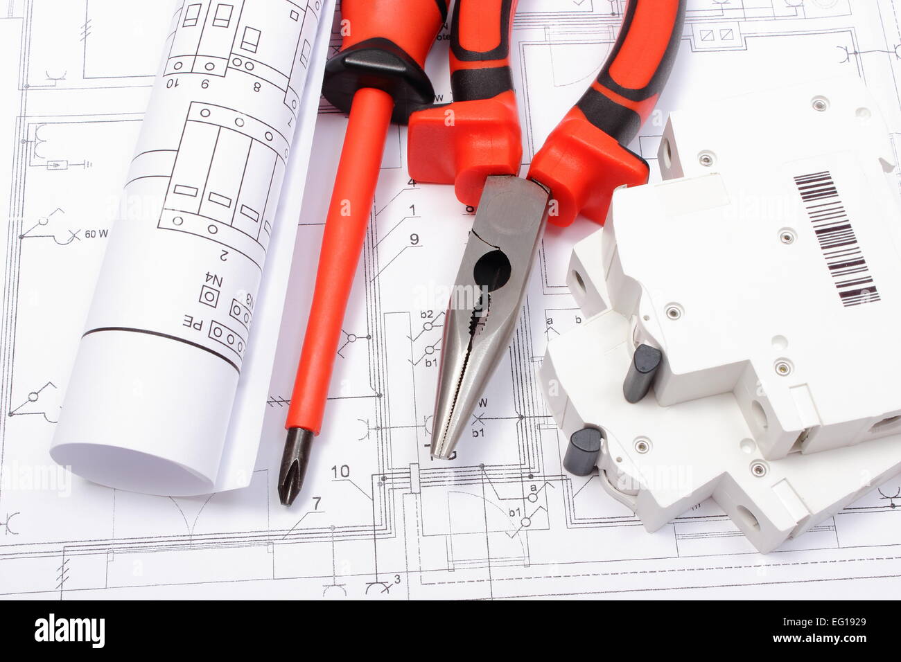 Rolled electrical diagrams, electric fuse and work tools lying on construction drawing of house, Stock Photo