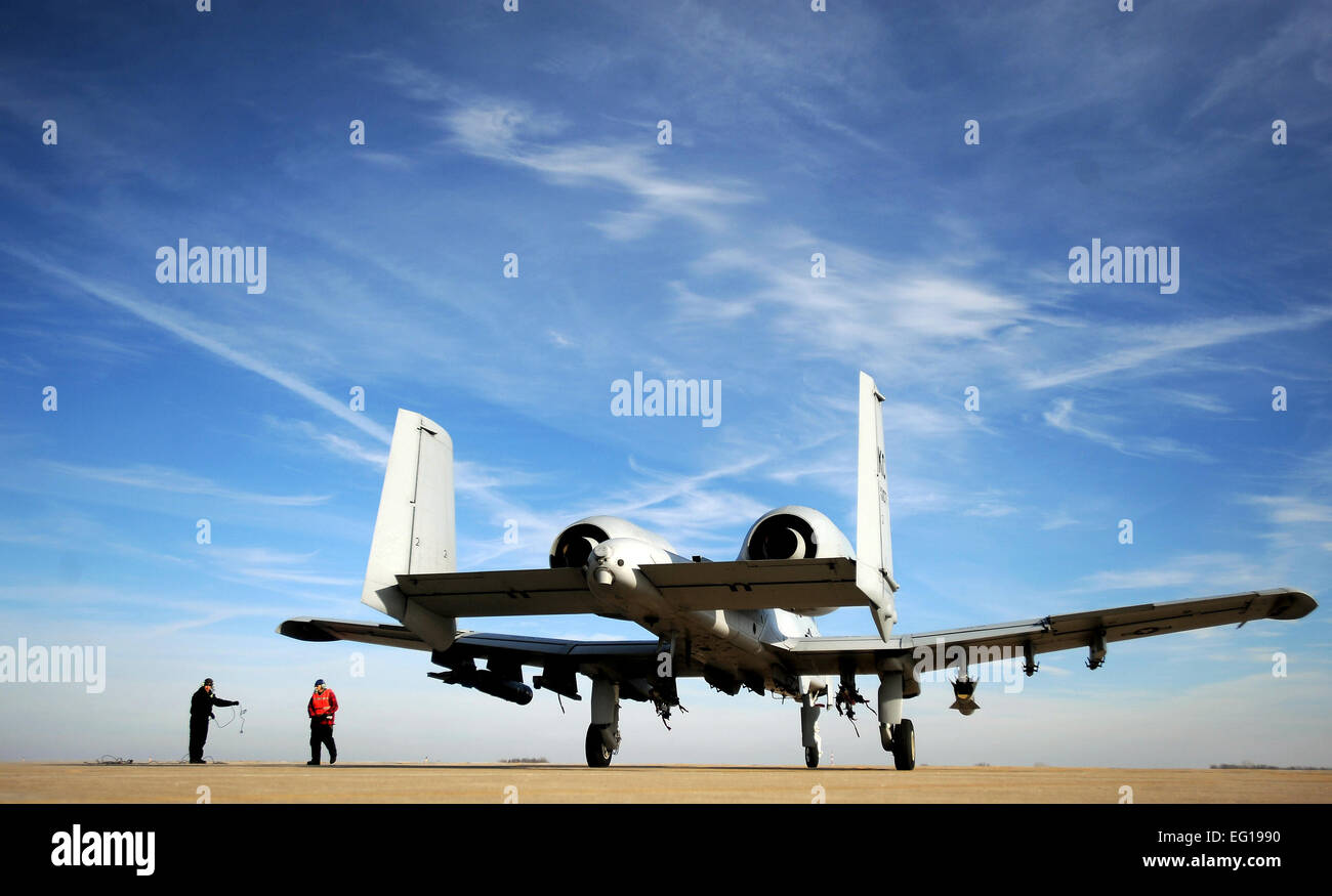 U.S. Air Force Air Reserve technicians assigned to the 442nd Fighter Wing clear the ramp as a U.S. Air Force A-10 Thunderbolt II taxies out of the hot pit after a hasty refuel at Whiteman Air Force Base, Mo., Dec. 8, 2010. Hot pit refueling is a procedure usually performed in a combat situation to rapidly refuel aircraft while their engines are running, resulting in a speedy refuel to thrust pilots right back into the fight. The 442nd Air Reserve technicians practice this procedure to keep their skills sharp.  Senior Airman Kenny Holston Stock Photo