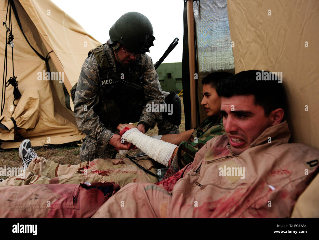 U.S. Air Force Capt. John Cleckner II, a critical evacuation nurse assigned to the 1st Special Operations Support Squadron, Hurlburt Field, Fla., bandages a 'patient's' arm during a mass casualty exercise for Emerald Warrior, March 4, 2011. Emerald Warrior is a U.S. Special Operations Command-sponsored, multiservice exercise designed to leverage lessons learned from Operations Iraqi Freedom and Enduring Freedom to provide trained and ready forces to combatant commanders. USAF photo by SSgt Andy M. KinReleased Stock Photo