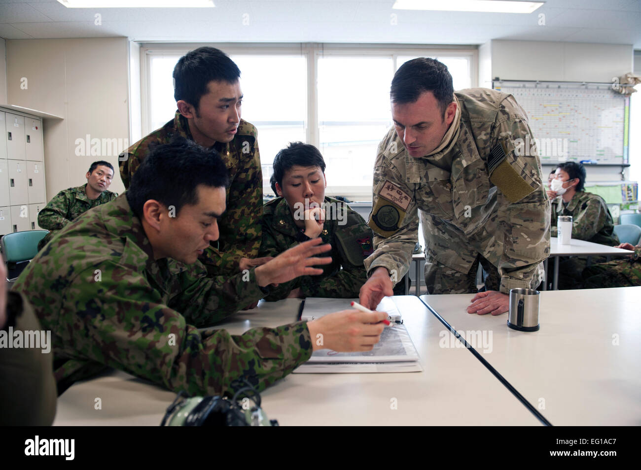 U.S. Air Force Maj. John Traxler, the 320th Special Tactics Squadron commander, and members of the Japan Ground Self-Defense Force discuss the possibility of using Yamagata as a fuel staging area March 13, 2011. The area would be used to refuel aircraft assisting with Japan's earthquake and tsunami recovery efforts.  Staff Sgt. Samuel Morse Stock Photo
