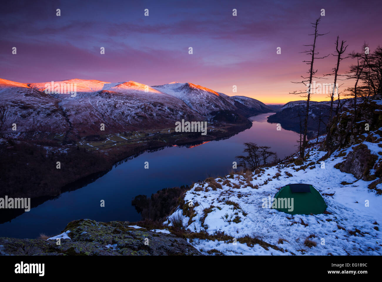 Wild camp tent at twilight after a beautiful pink sunset at Raven Crag, Lake Thirlmere in the English Lake District. Stock Photo