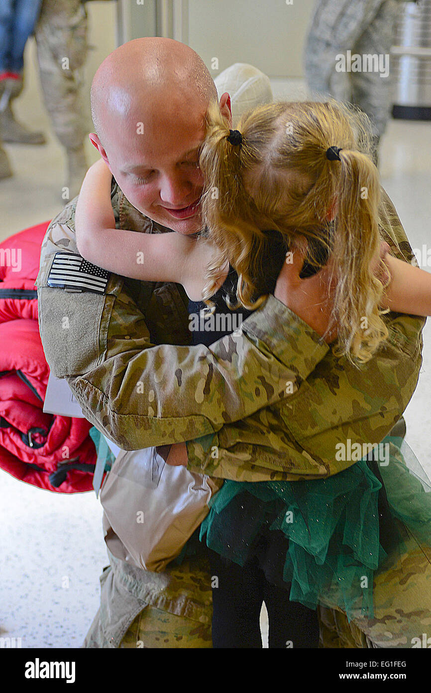 Senior Airman Mark Delaney, 748th Aircraft Maintenance Squadron, hugs his daughter at Royal Air Force Mildenhall Sept. 19, 2013, following an almost four-month deployment to Bagram Airfield, Afghanistan. Nearly 100 Airmen from the 56th Rescue Squadron and 748th AMXS, stationed at RAF Lakenheath, returned this week.  Airman 1st Class Dana J. Butler Stock Photo