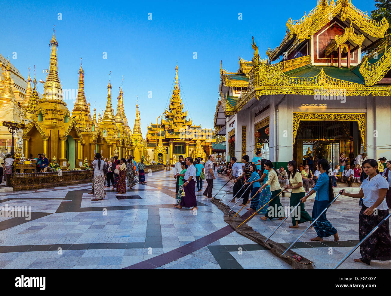 Myanmar, Yangon, young local religious cleaning the floor of the Swedagon Pagoda. Stock Photo