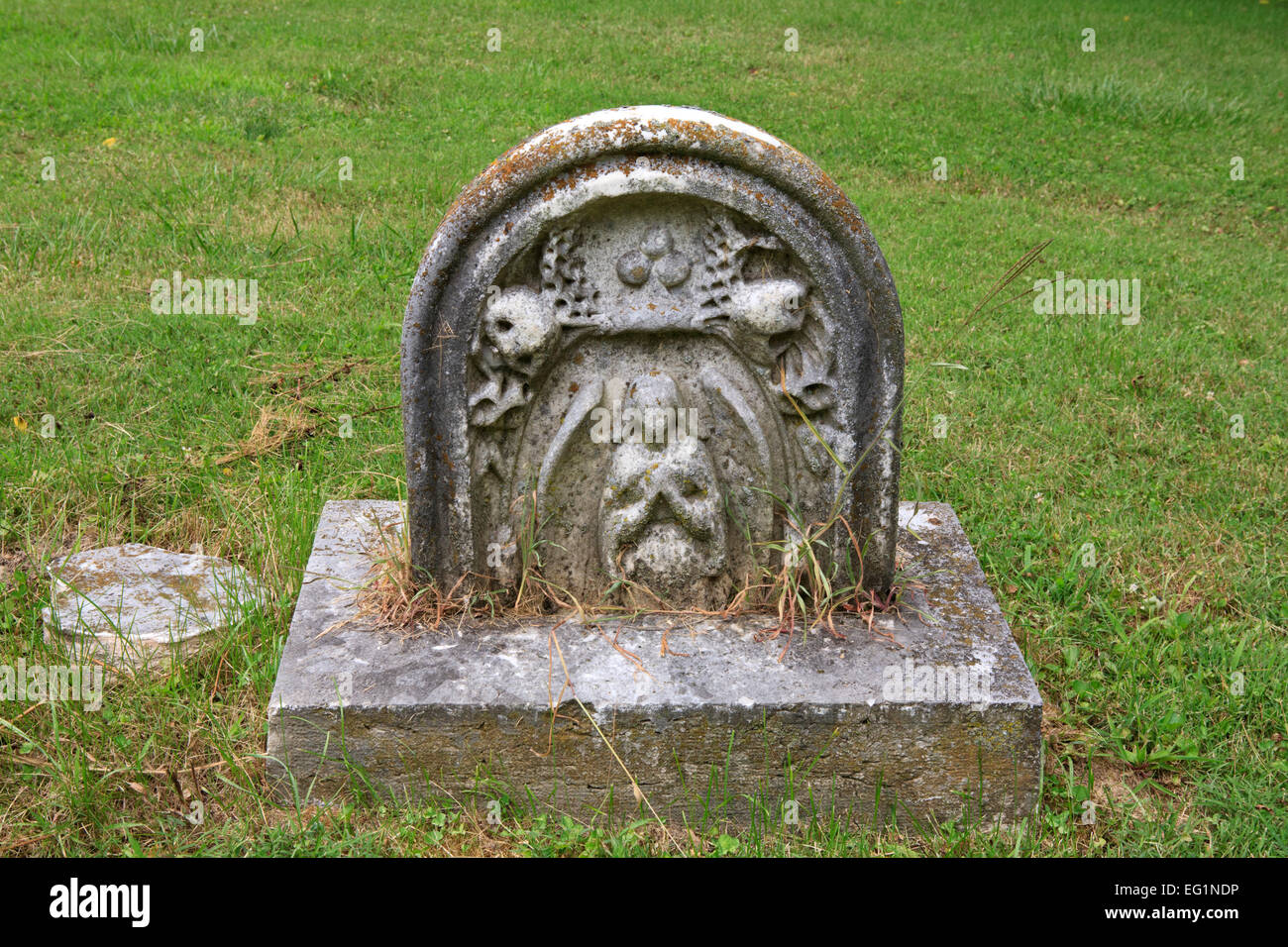 Old gravestone with the figure of a man with crossed arms. Stock Photo