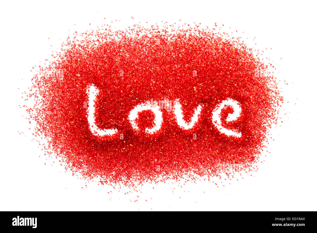 background using red sugar on a white background and the word love spelled in it Stock Photo