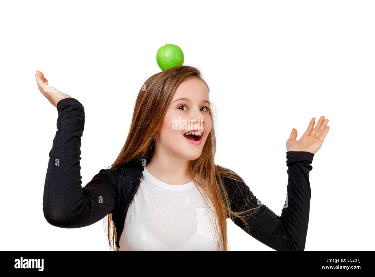 Little girl with green apple on head isolated on white Stock Photo