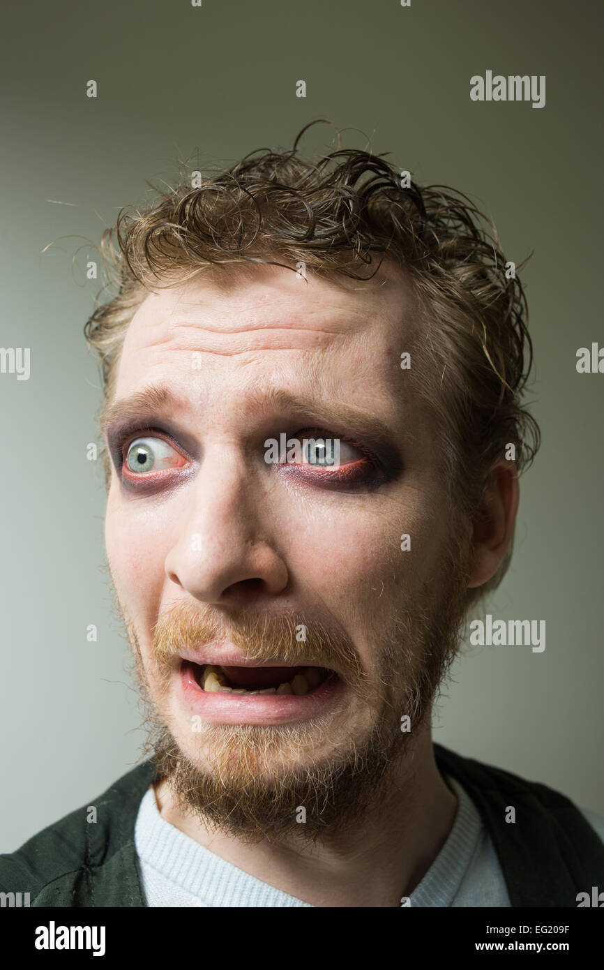 frightened man with red painted eyes. Stock Photo