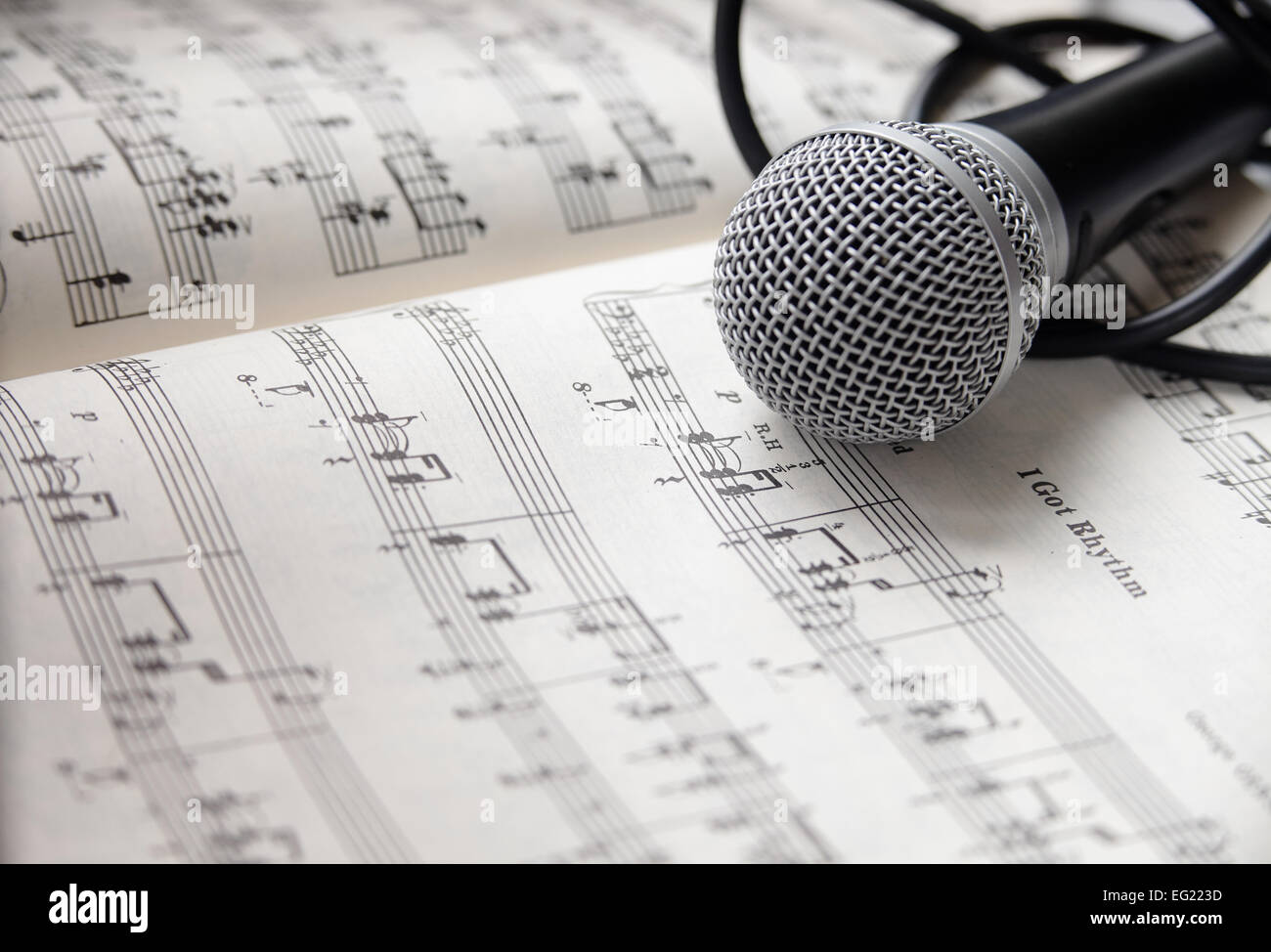 Microphone and cable lying on sheet of music Stock Photo Alamy