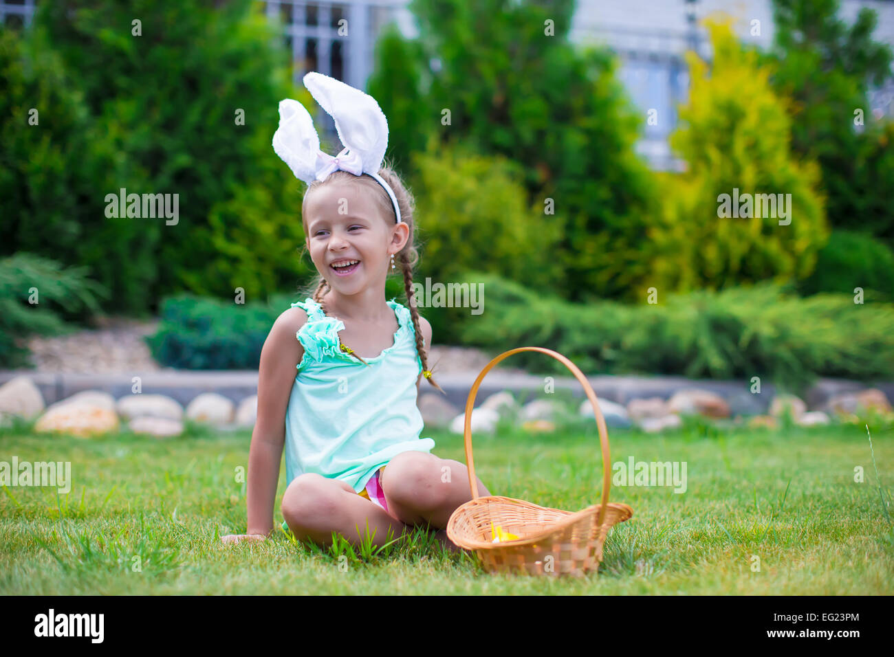 Adorable little girl wearing bunny ears holding basket with Easter eggs ...