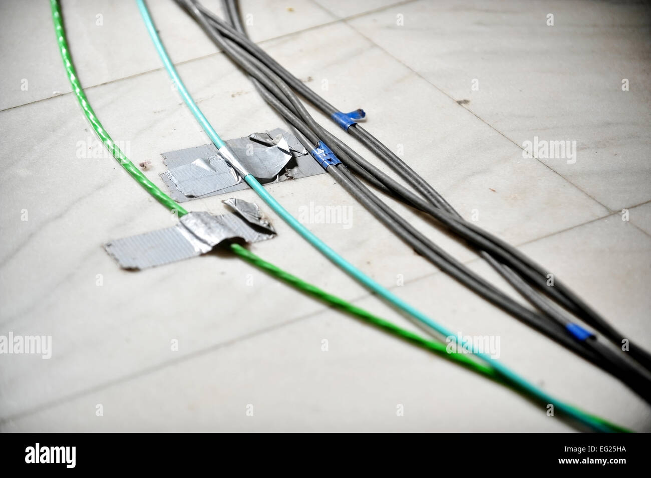 Detail with electric television cables fixed on the floor with duct tape Stock Photo