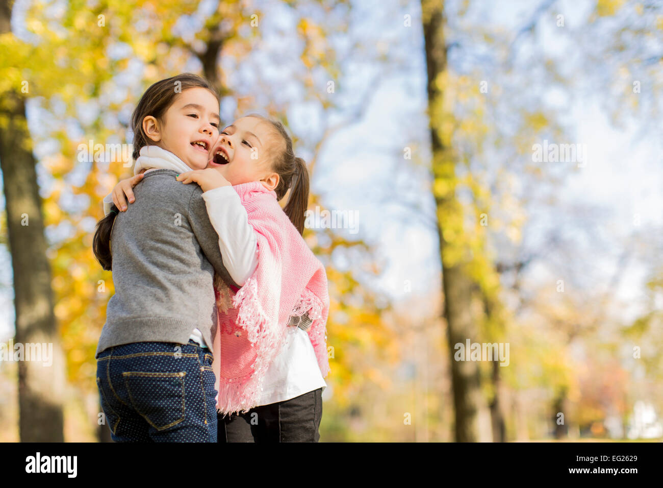 Cute little girls in the autumn park Stock Photo - Alamy