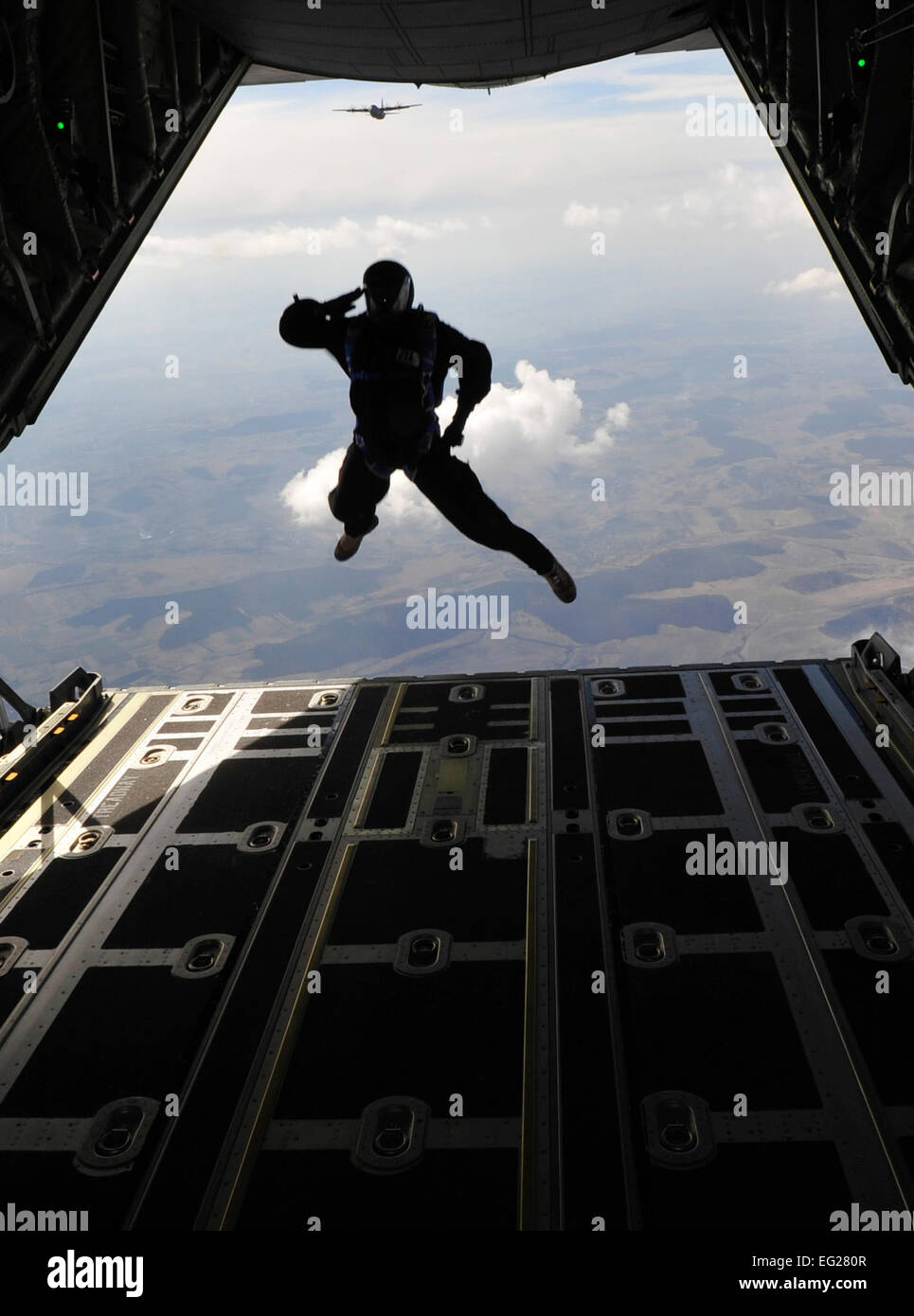 Master Sgt. Robert Zackery salutes as he exits a C-130J Super Hercules during a combined high-altitude, low-open, jump March 18, 2011, over a landing zone near Campia Turzii, Romania. This jump was conducted as part of Carpathian Spring 2011, an exercise where members of the U.S. military joined their Romanian counterparts to learn from one another and strengthen alliances. Sergeant Zackery is a jumpmaster assigned to the 4th Air Support Operations Group.  Tech. Sgt. Jocelyn L. Rich Stock Photo
