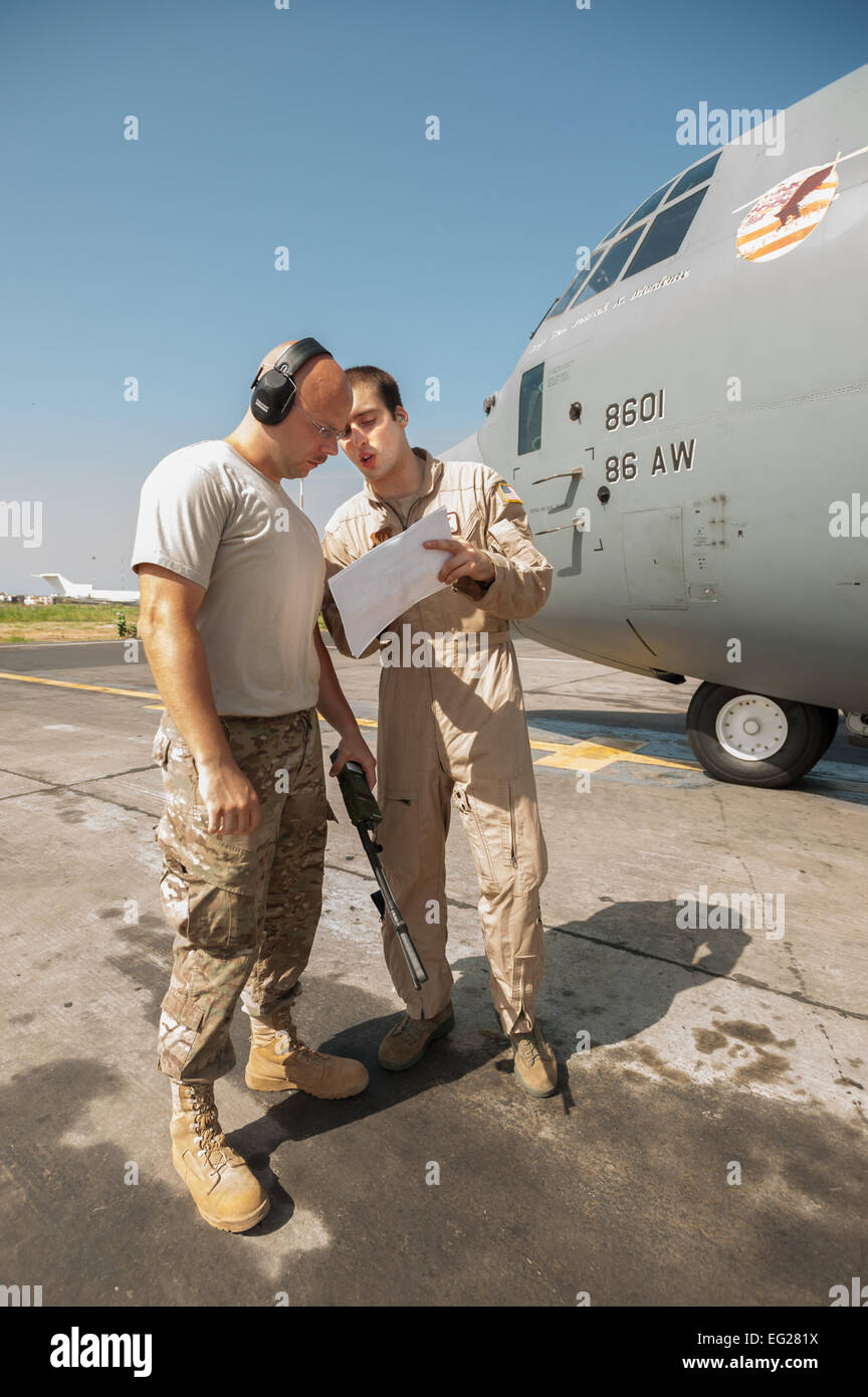 Tech. Sgt. Jarrod Blanford, an aerial porter from the Kentucky Air National Guard’s 123rd Contingency Response Group, reviews a cargo manifest with Airman 1st Class Evan Kuehl, 86th Airlift Wing loadmaster, prior to the departure of a C-130 Hercules from Léopold Sédar Senghor International Airport in Dakar, Senegal, Oct. 22, 2014. The flight is bound for Liberia, carrying whole blood and U.S. Army Soldiers supporting Operation United Assistance, the U.S. Agency for International Development-led, whole-of-government effort to respond to the Ebola outbreak in West Africa.  Maj. Dale Greer Stock Photo