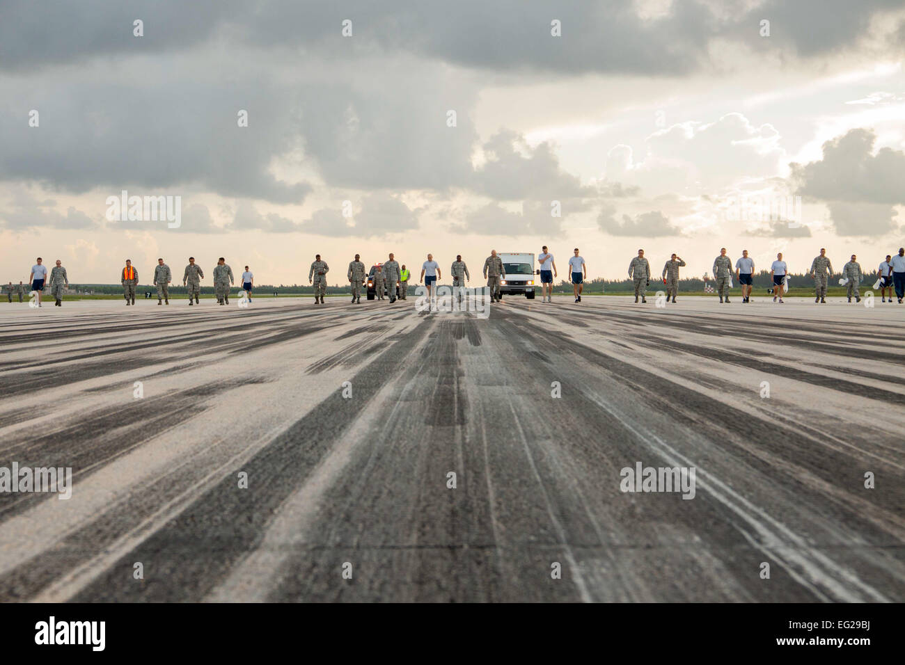 Members of the 482nd Fighter Wing perform a foreign object debris walk as part of Wingman Day July 12, 2014, on Homestead Air Reserve Base, Fla. A FOD walk is conducted to remove potentially dangerous debris from the flightline and prevent damage to aircraft fuselage and engines.  Senior Airman Jaimi L. Upthegrove Stock Photo