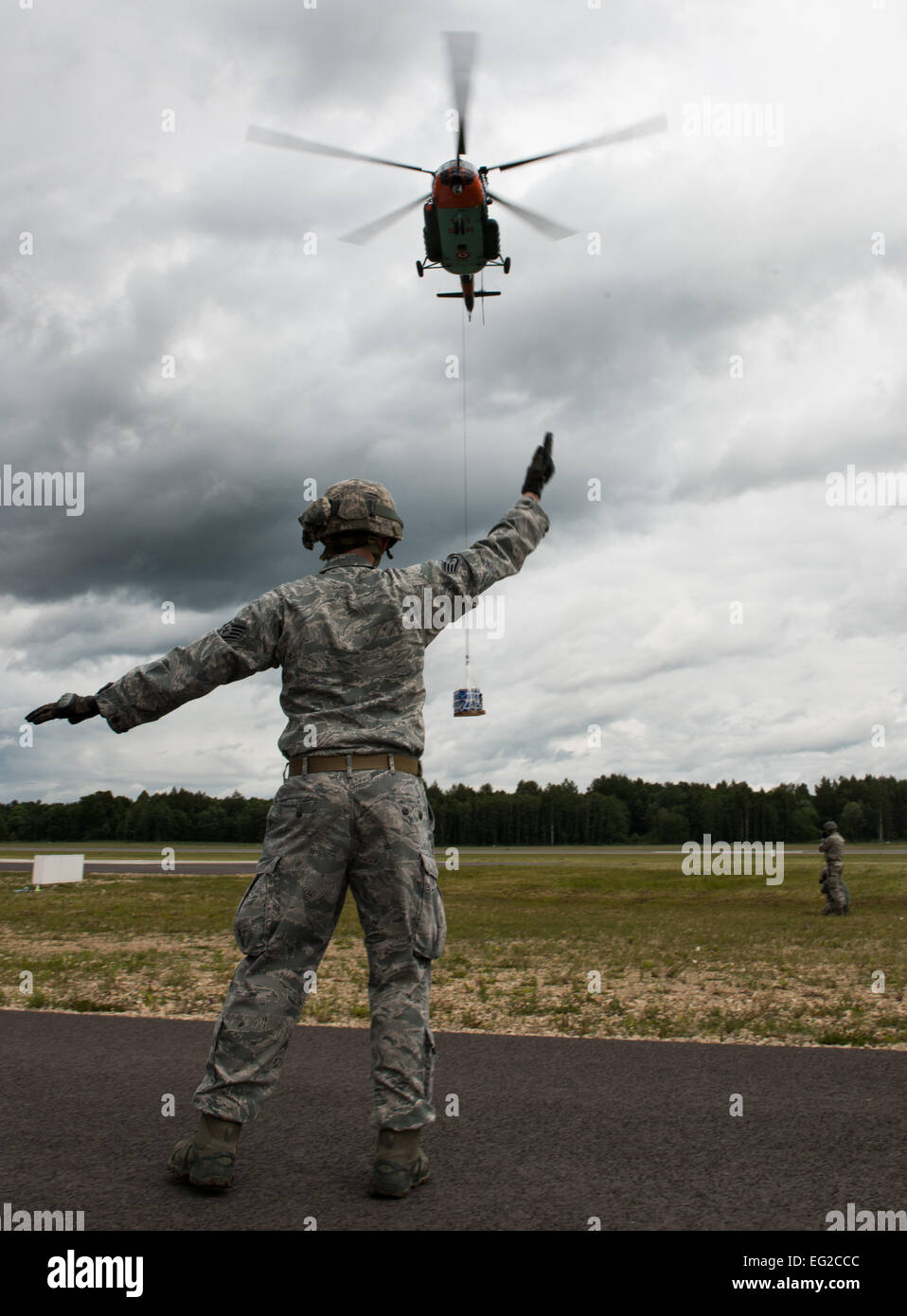 Staff Sgt. Timothy Kennedy marshals a Latvian Mi-8 helicopter during sling-load operations training at the Air Force-specific portion of Saber Strike June 17, 2014, on Lielvarde Air Base, Latvia. During the final week of Saber Strike 2014, the 435th Contingency Response Group, in conjunction with the 37th Airlift Squadron, trained on the full capabilities to open the Latvian air base. They also trained with Latvian and Estonian service members on airfield operations, command and control of air and space forces, weather support, and protection of operational forces, aircraft maintenance, and ae Stock Photo