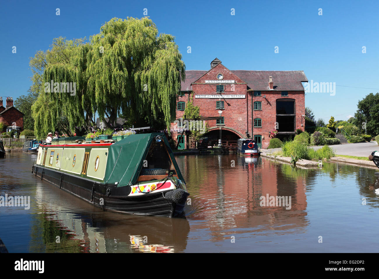 A narrowboat travelling in front of the Clock Warehouse on the Trent