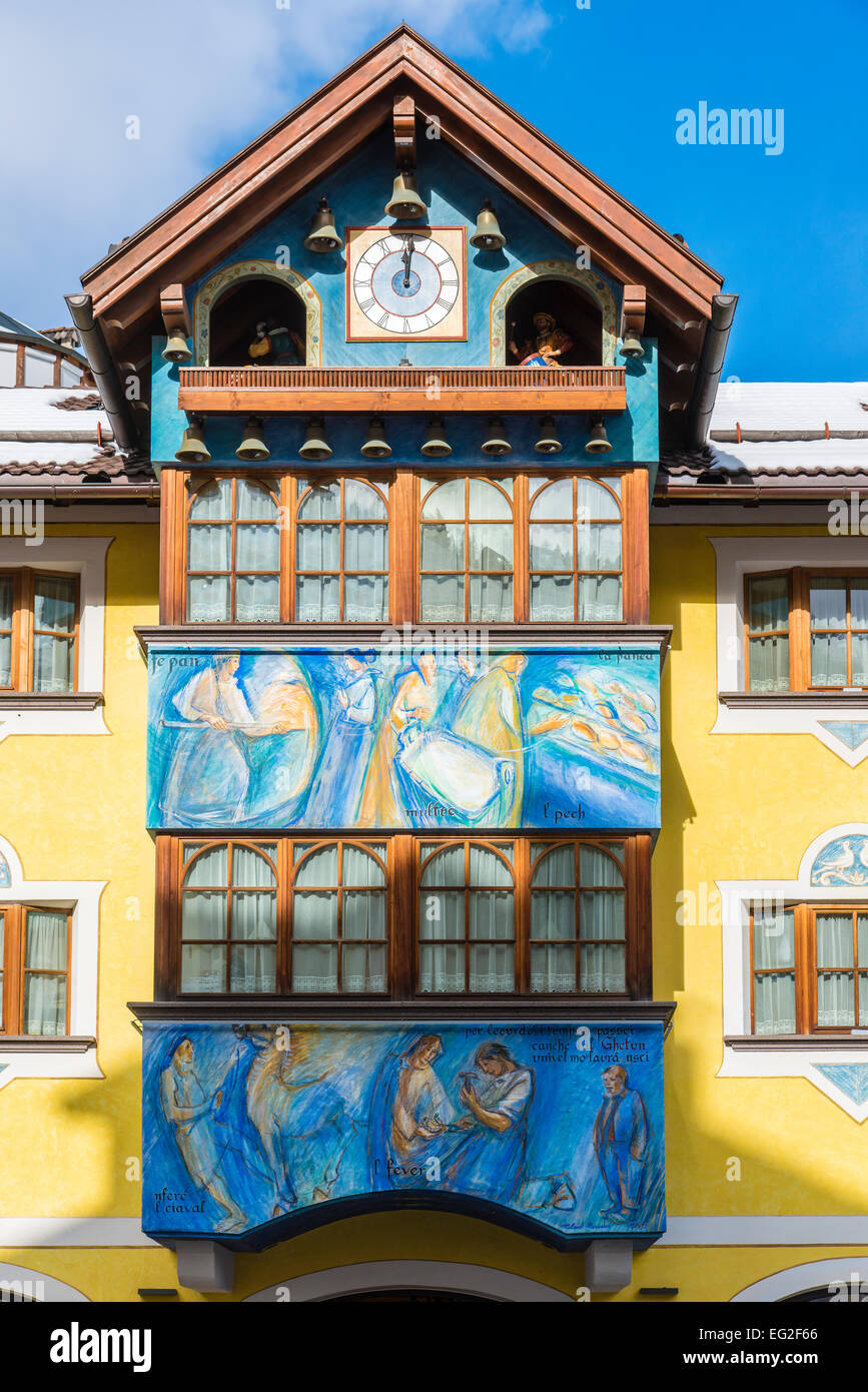 Colorful house facade with paintings and musical clock on the top, Selva di Val Gardena, Alto Adige South Tyrol, Italy Stock Photo
