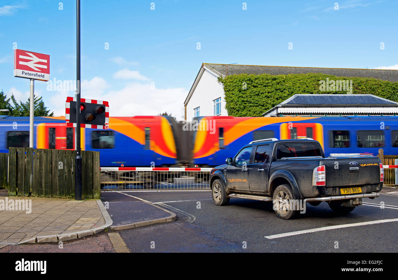 Train passing level crossing in Petersfield, Hampshire, England UK Stock Photo