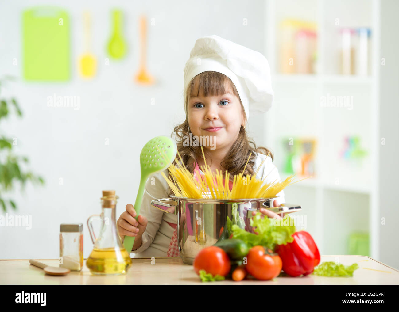 Child makes healthy vegetables meal in the kitchen Stock Photo