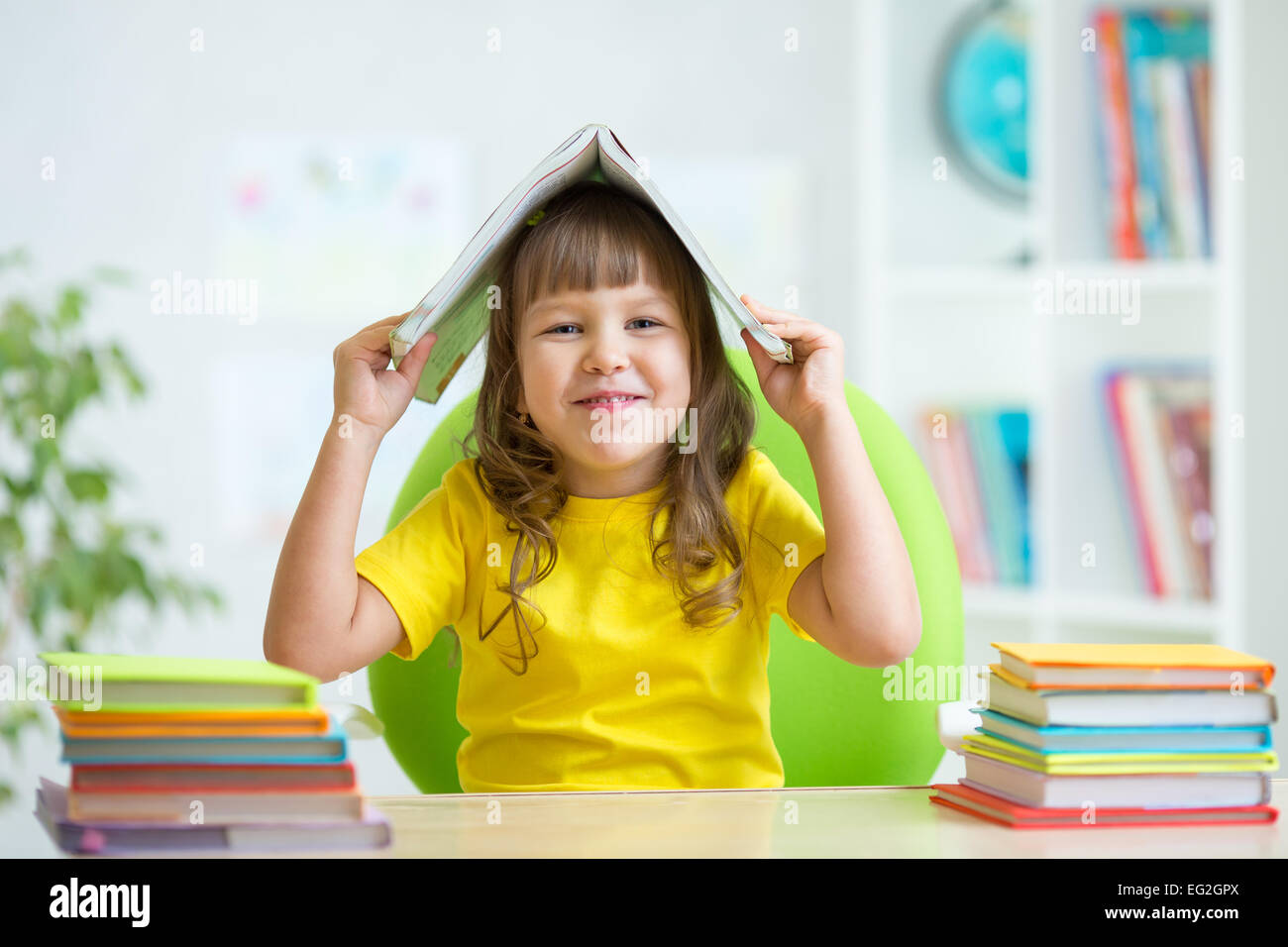 preschooler kid girl with book over her head Stock Photo - Alamy