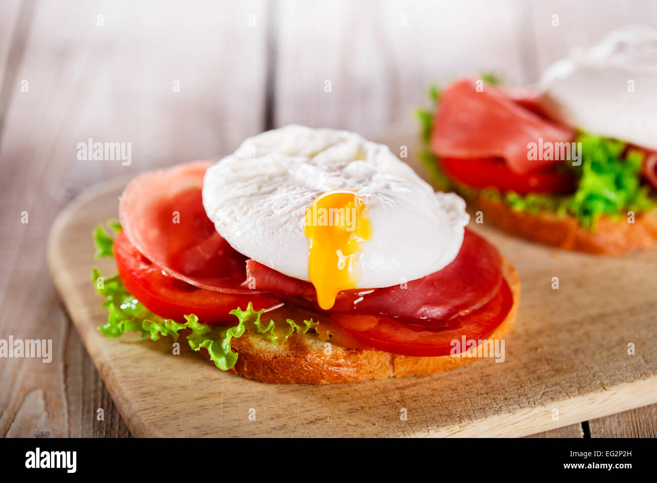 sandwich with prosciutto and poached egg tomato Stock Photo