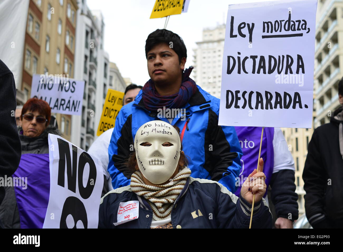 A woman wears a mask and a banner with the words 'Gag Law, shameless ...