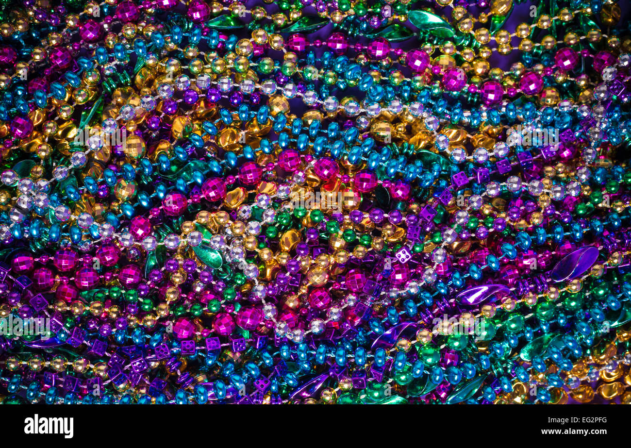 Background of large amount of mardi gras bead on a purple background Stock Photo