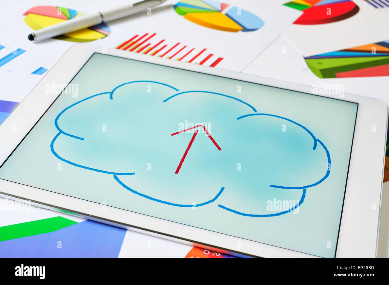 a drawing of a cloud with an arrow inside on the screen of a tablet, depicting the concept of upload to the cloud storage Stock Photo