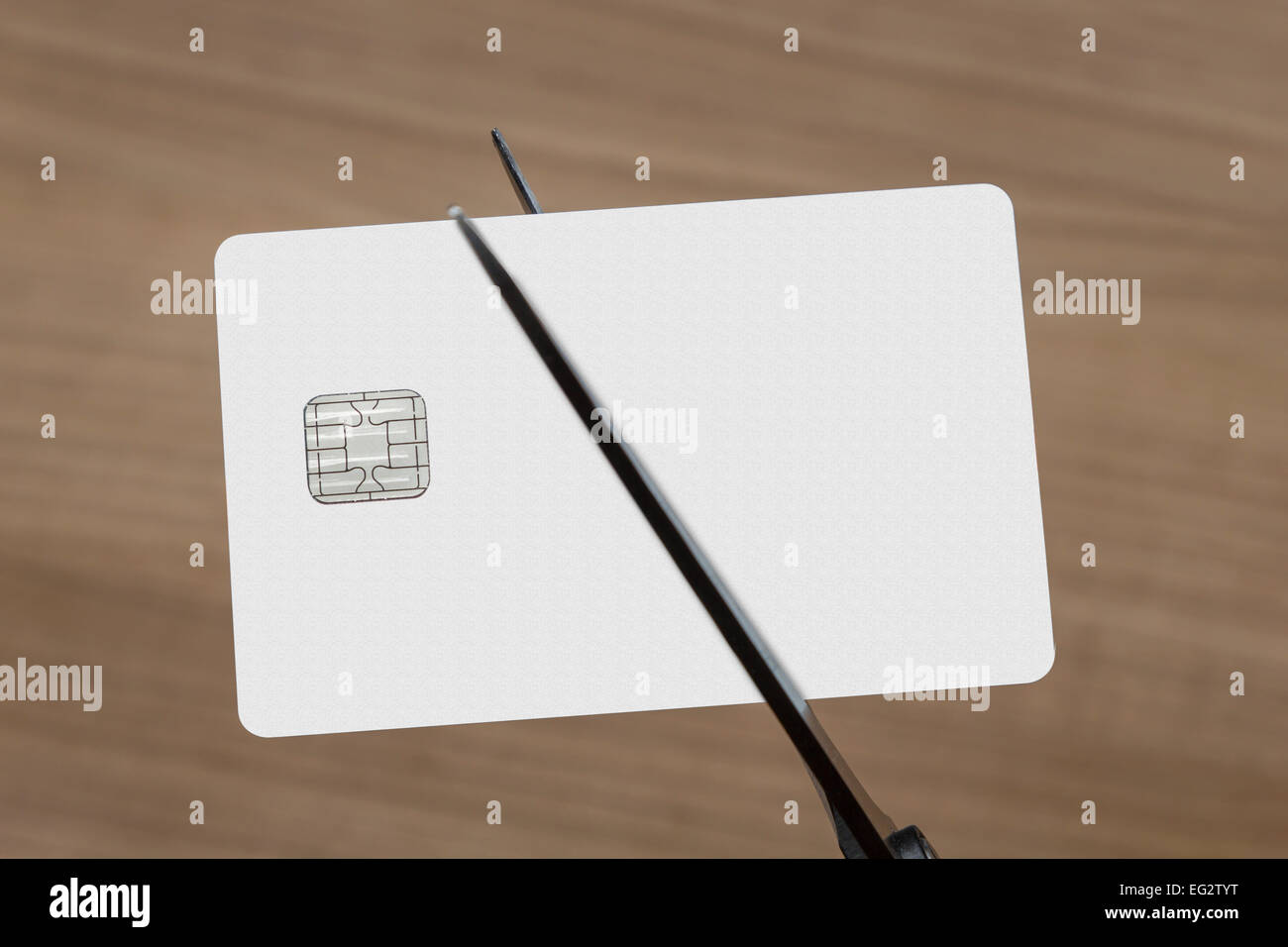 scissors cutting a blank white credit or debit card Stock Photo