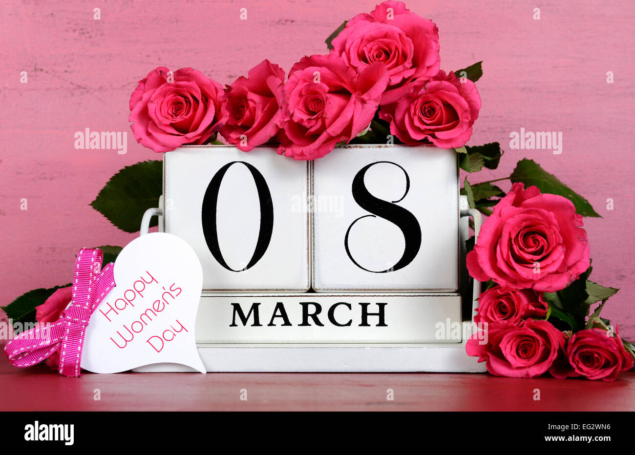 International Womens Day white vintage wood block calendar date for March 8, with roses on pink and red vintage wood background. Stock Photo
