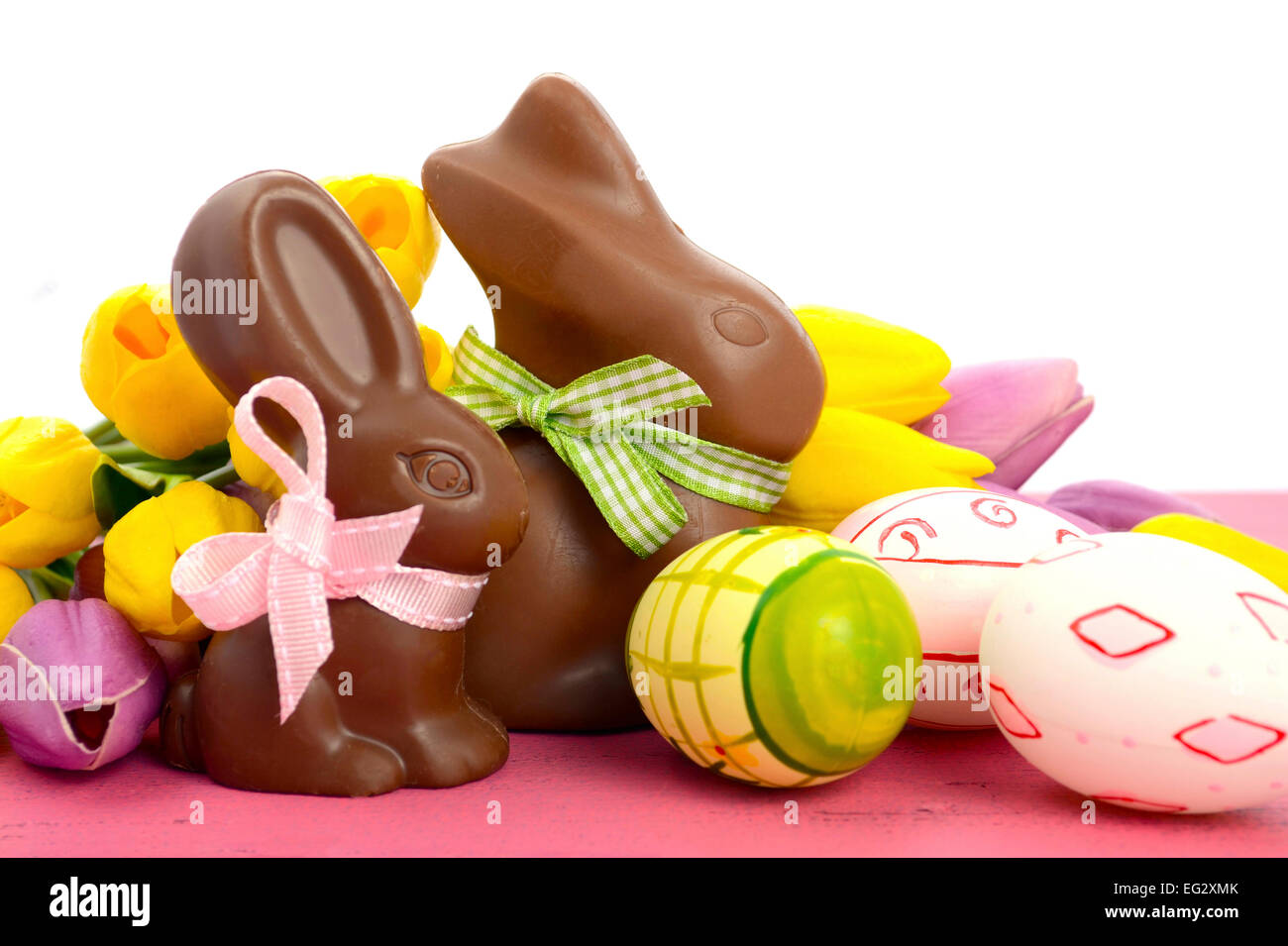 Happy Easter chocolate bunny rabbits with pink, white and green eggs on