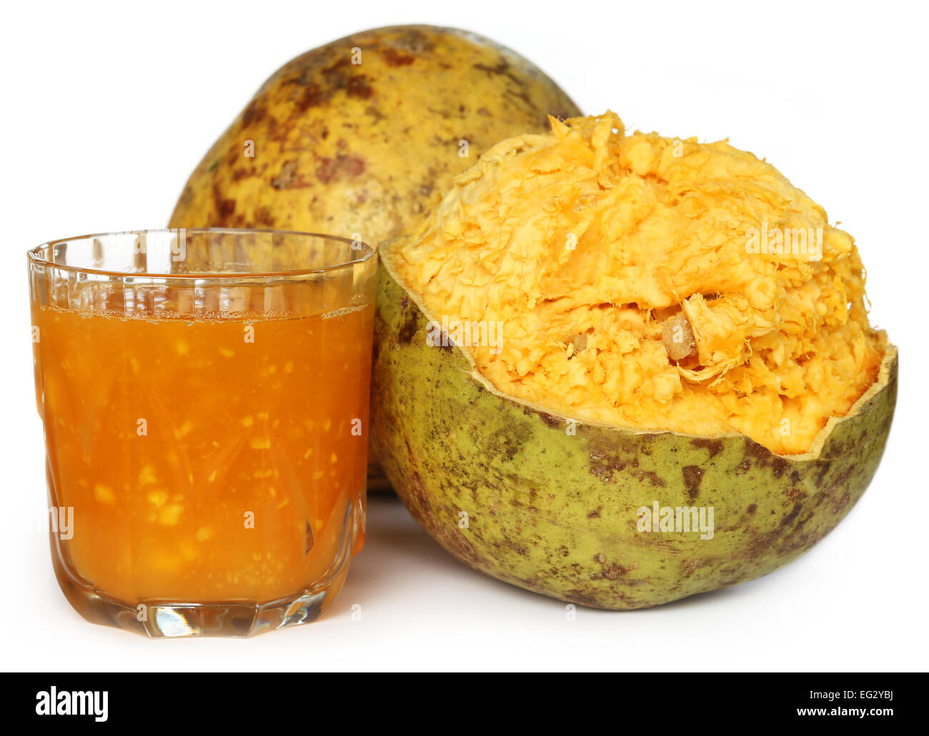Medicinal Bael fruit with juice over white background Stock Photo