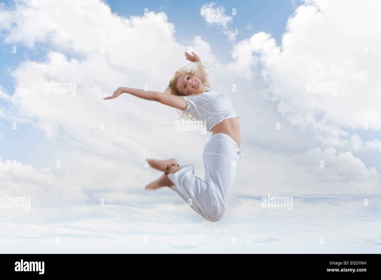 Portrait of young jumping woman on blue sky background Stock Photo - Alamy