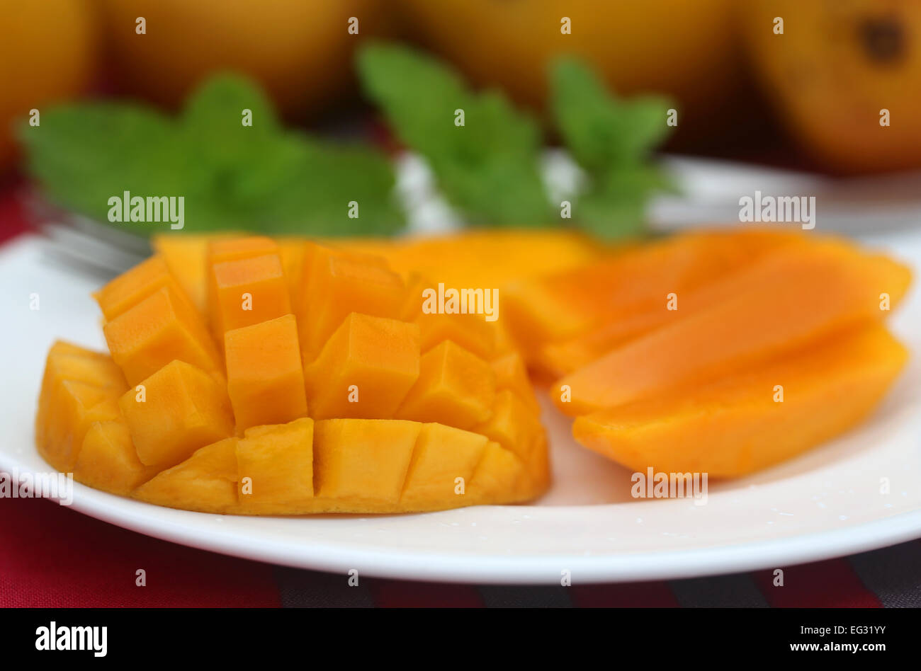 Ripe mangoes with mint leaves on a plate Stock Photo