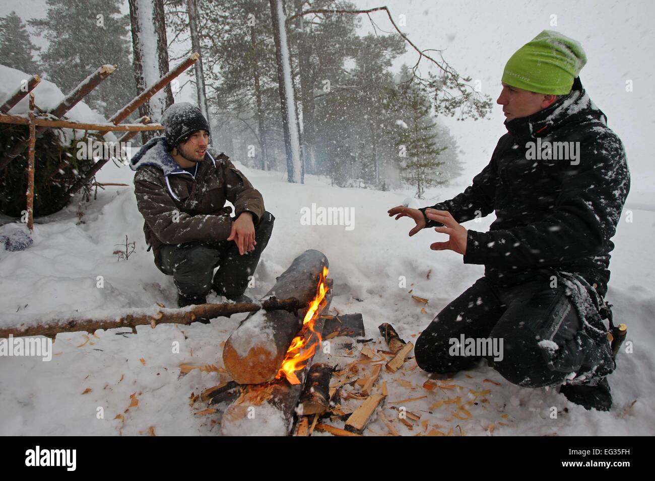 Helsinki, Finland. 12th Feb, 2015. A Finnish coach (R) teaches a French tourist how to set fire on snow in Savukoski, northern Finland, on Feb. 12, 2015. As being trained to live in Arctic wilderness is becoming a popular recreation, many European choose to travel to Finnish Lapland to spend their winter vacations. © Li Jizhi/Xinhua/Alamy Live News Stock Photo