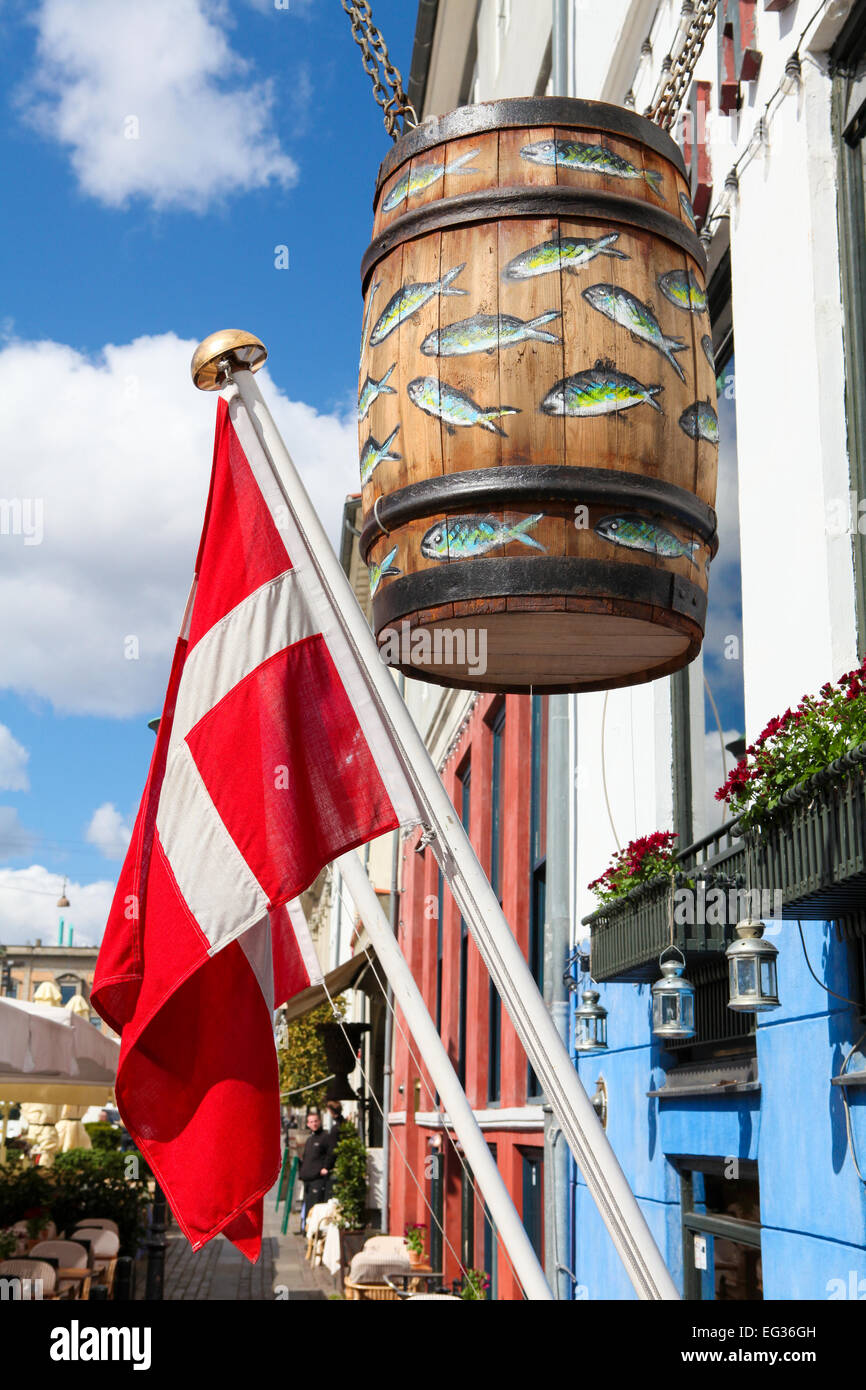 COPENHAGEN, DENMARK - APRIL 19, 2010: Danish flag and big wooden barrel decorated with painted fish at a traditional herring res Stock Photo