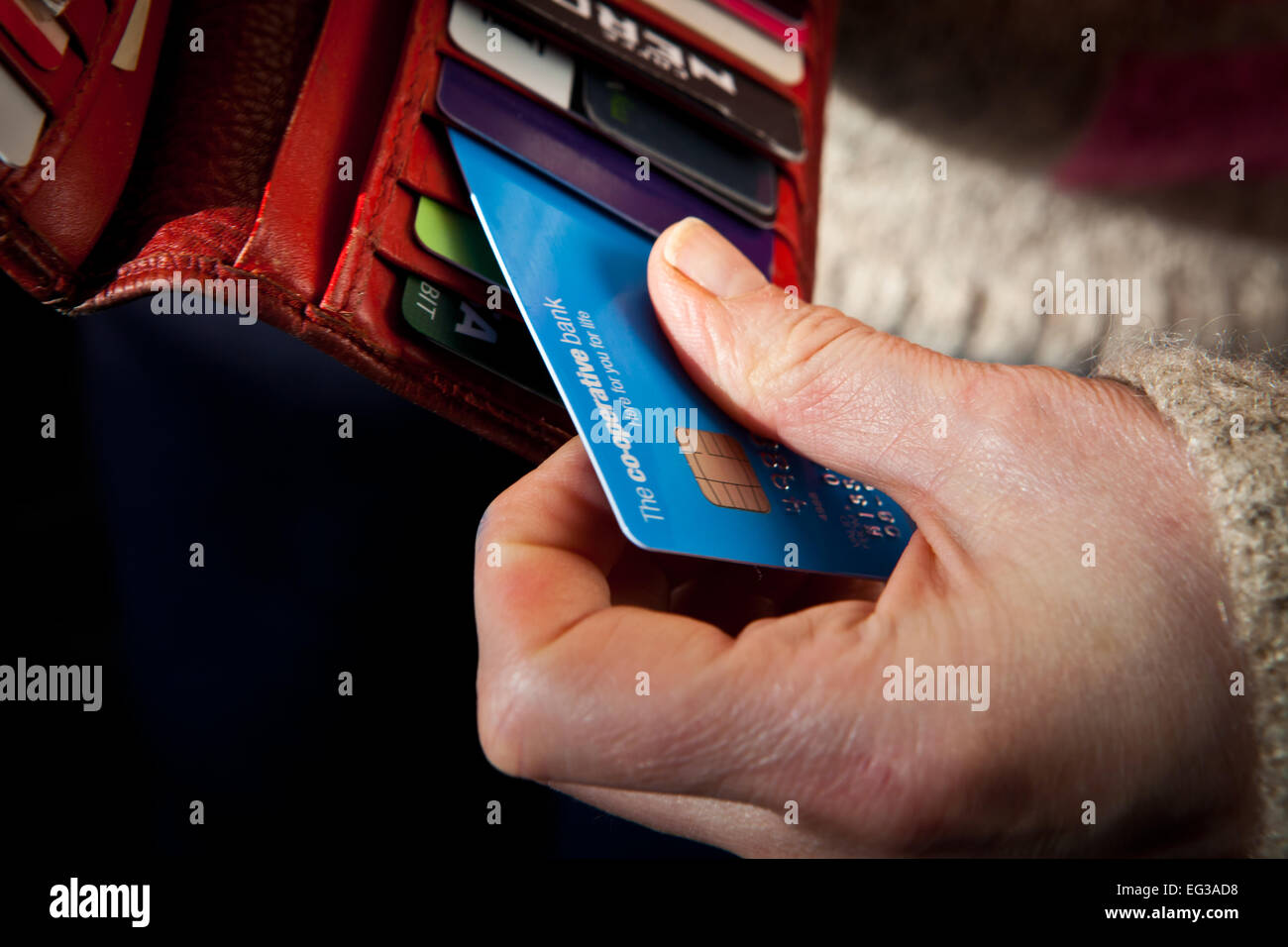 Woman taking Co-Operative debit card from purse Stock Photo