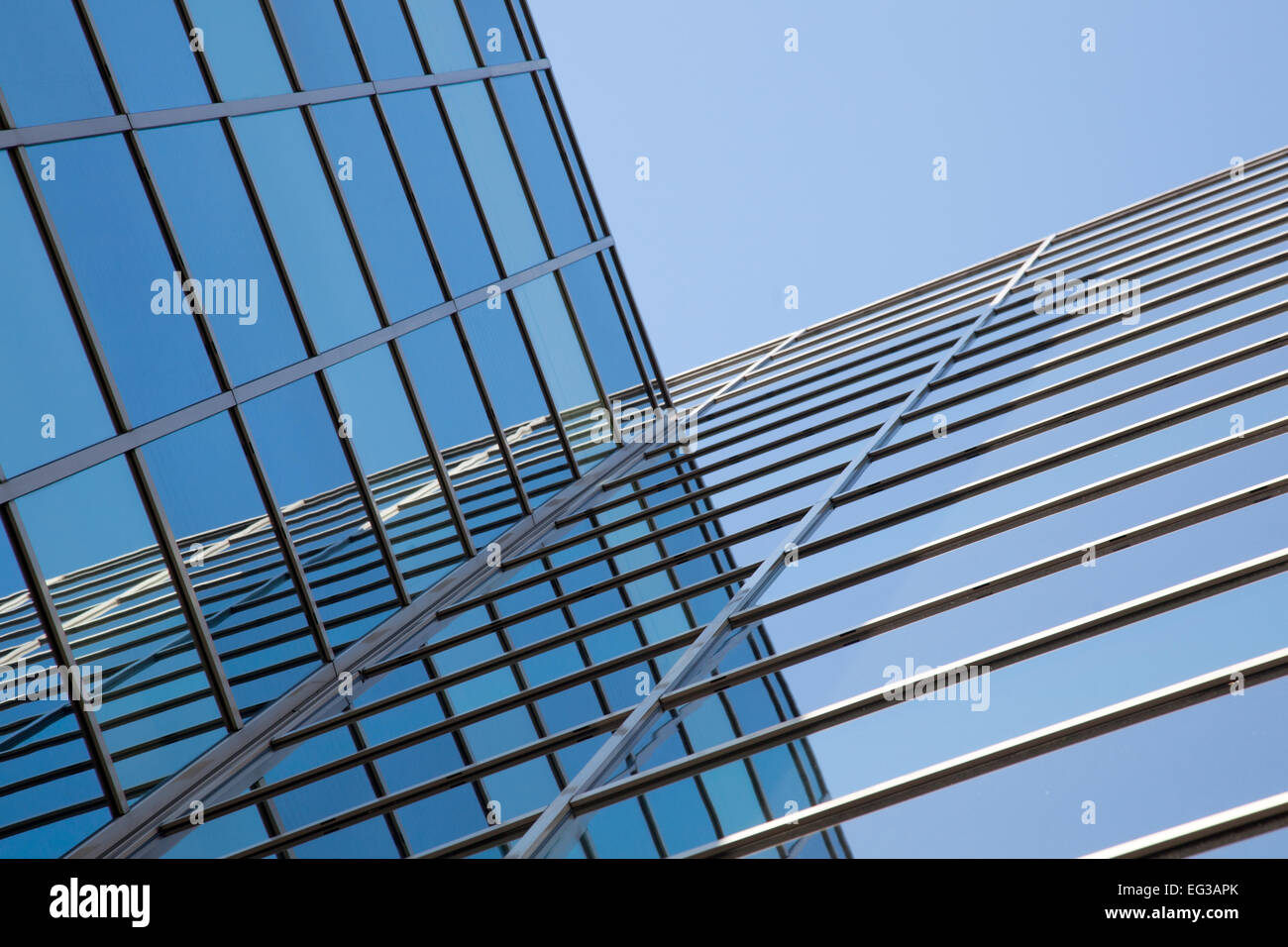 glass facade of modern office building and reflections of blue sky ...