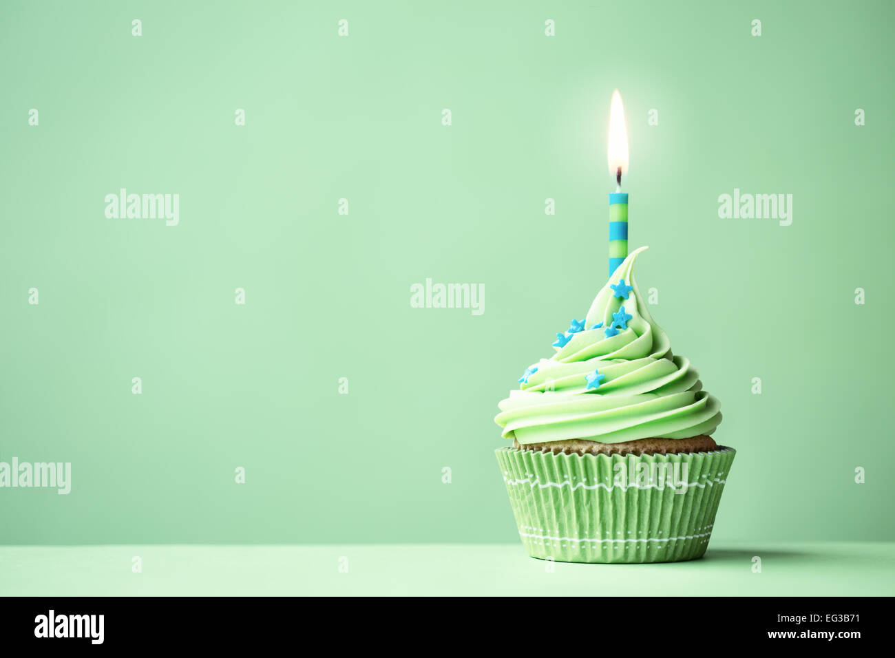 Green birthday cupcake with copy space to side Stock Photo - Alamy