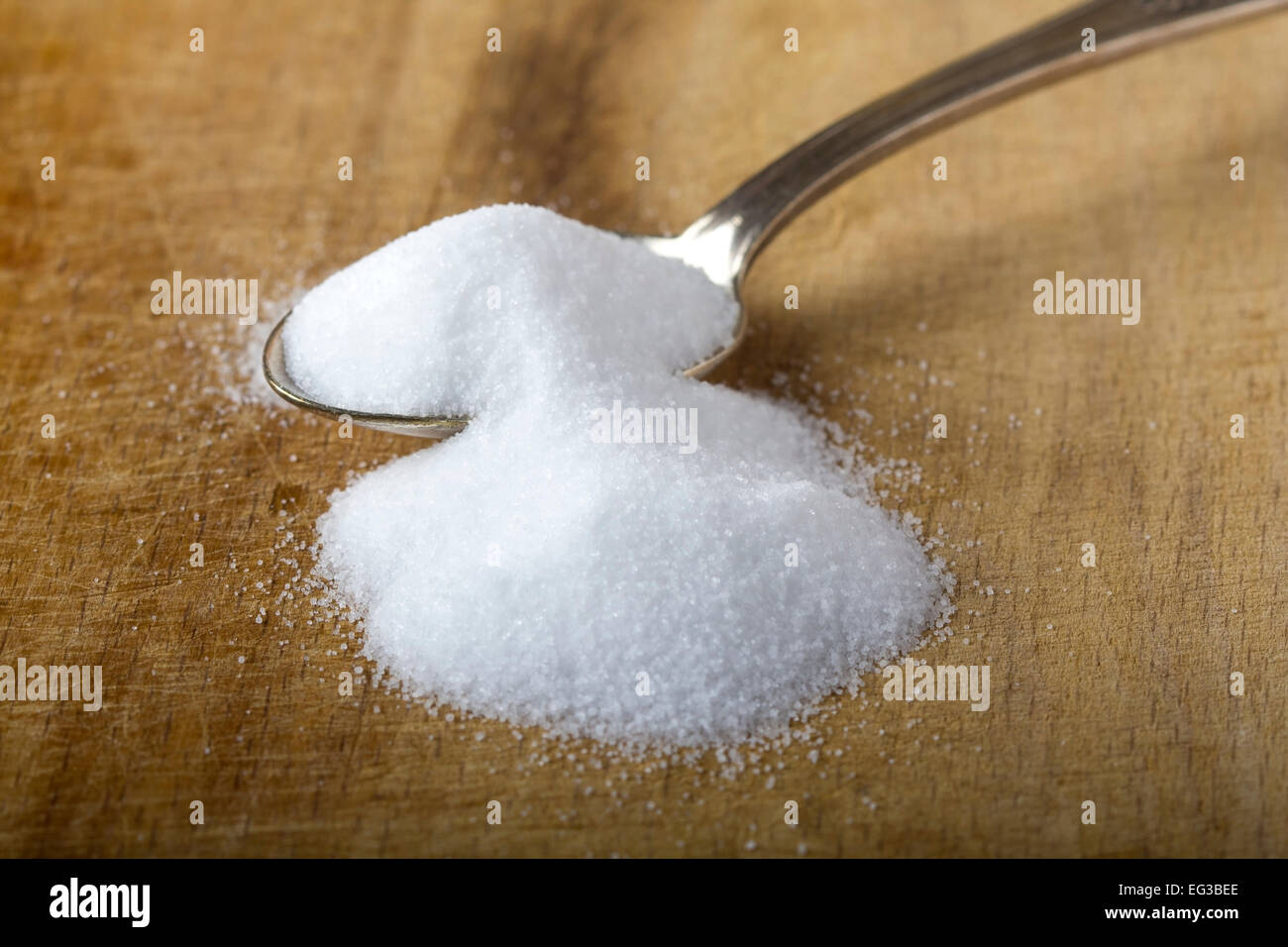 Silver spoon of baking soda over wood background Stock Photo