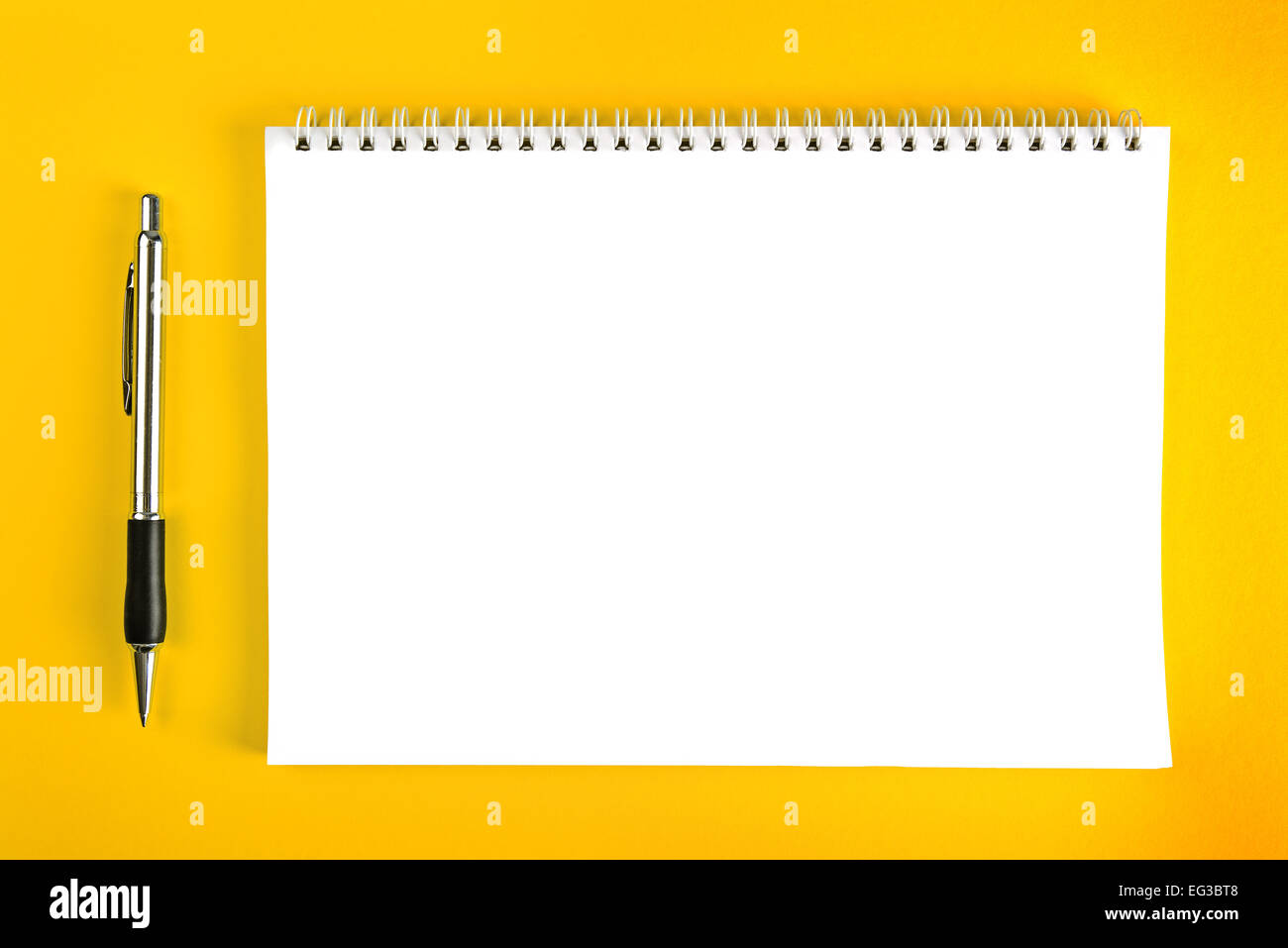 Ballpoint Pen and Blank Paper Notebook with Spiral Binding as Business Copy  Space on Yellow Background Stock Photo - Alamy