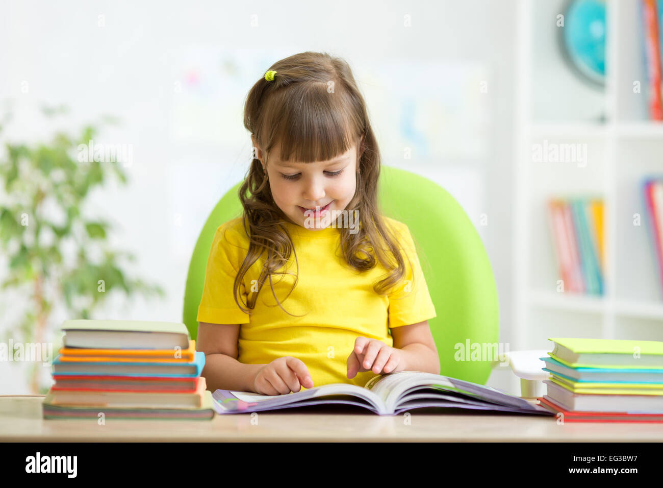 Happy child learning to read in nursery Stock Photo